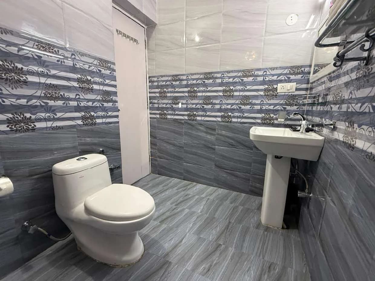 Bathroom with grey floor and floral wall-tile band